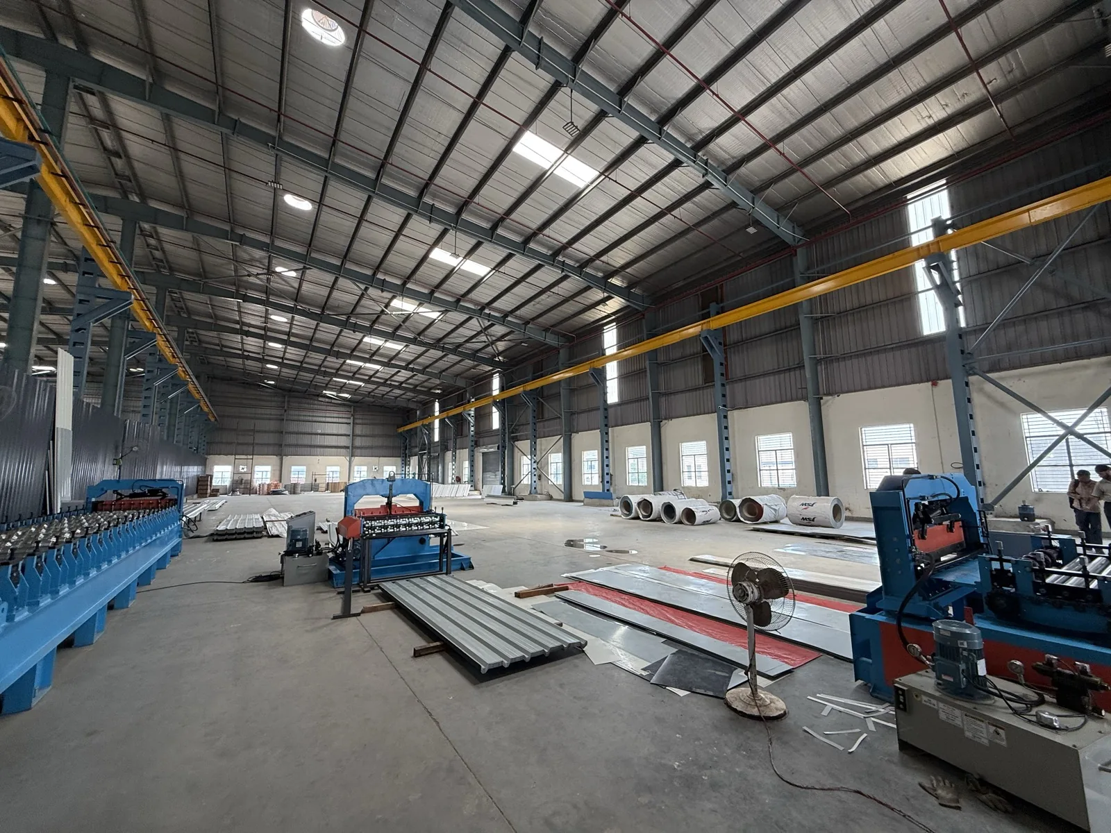Panorama of the plant floor with roll-forming lines and steel coils